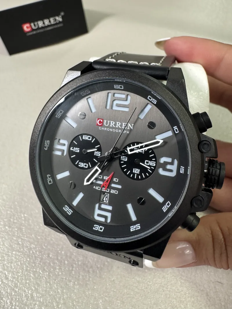 Curren 8314 negro en la mano, con su caja al fondo