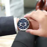 Curren 8363 plateado con esfera azul, puesto en la muñeca con camisa y saco