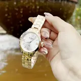 Curren 9007 dorado con esfera plateada, sostenido en la mano